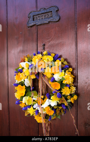 UK Cheshire Vale Royal Great Budworth Dorf Kranz aus frischen Frühlingsblumen an Eingangstür hängen Stockfoto