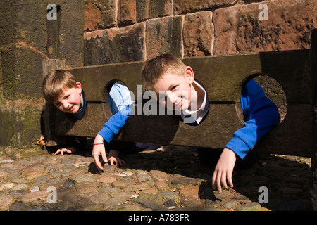 UK Cheshire Vale Royal Great Budworth zwei jungen im Dorf Bestände am St Marys Parish Kirche Lynch Tor Stockfoto