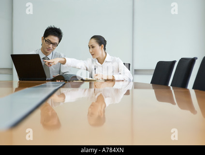Zwei Geschäftsleute arbeiten mit Laptop im Konferenzraum Stockfoto