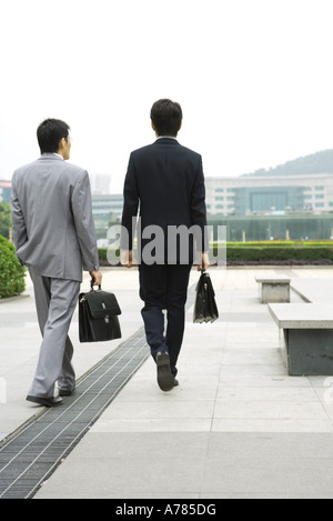 Zwei Geschäftsleute, die zu Fuß in Office Park, Rückansicht Stockfoto