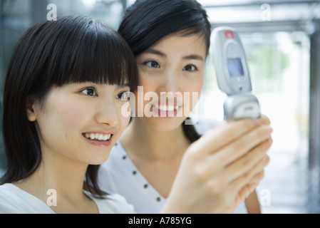 Zwei junge Freundinnen Blick auf Handy zusammen, Nahaufnahme Stockfoto