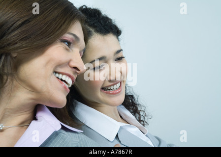 Zwei Geschäftsfrauen sitzen Kopf an Kopf, Lächeln Stockfoto