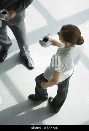 Büro-Mitarbeiter stehen mit Kaffeetassen, erhöhte Ansicht Stockfoto