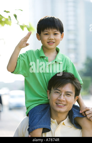 Mann mit Sohn auf Schultern, junge Geste Stockfoto