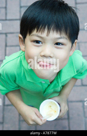 Junge, Eis essen, Lippen lecken Stockfoto