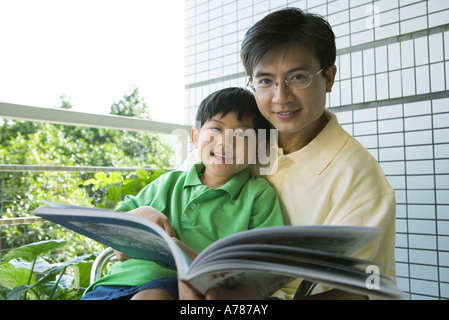 Vater und Sohn Lesebuch, lächelnd in die Kamera Stockfoto