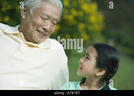 Mädchen und Großvater, Lächeln einander an Stockfoto