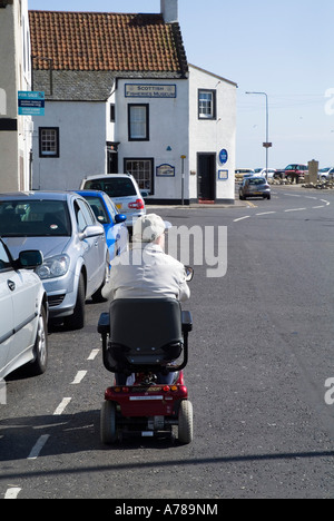 dh Mobility Scooter DISABILITY UK Schottland Behinderter Mann fährt Buggy Fahrzeug Straße Ältere unabhängige Invalid Person Care Stockfoto