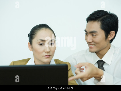 Zwei Geschäftspartner mit Computer, Mann in Richtung Bildschirm Stockfoto