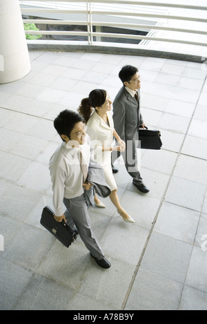 Drei Führungskräfte gehen nebeneinander, hoher Winkel anzeigen Stockfoto