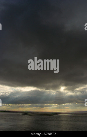 dämmerungsaktiv Sonnenstrahlen durchbrechen Gewitterwolken über Morecambe Bucht in england Stockfoto