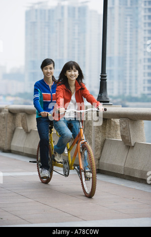 Zwei junge Frauen mit Tandem Fahrrad Stockfoto