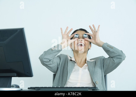 Geschäftsfrau hält Yinyang Kugeln vor Augen, lachen Stockfoto
