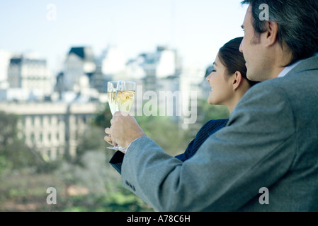 Geschäftspartner halten Gläser Champagner, Skyline im Hintergrund Stockfoto