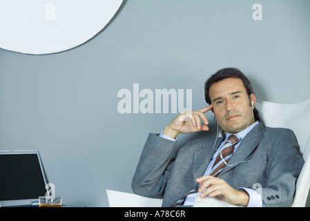 Geschäftsmann, Kopfhörer, hören Blick in die Kamera Stockfoto