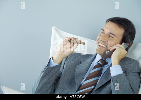 Geschäftsmann mit Handy und rauchende Zigarre Stockfoto