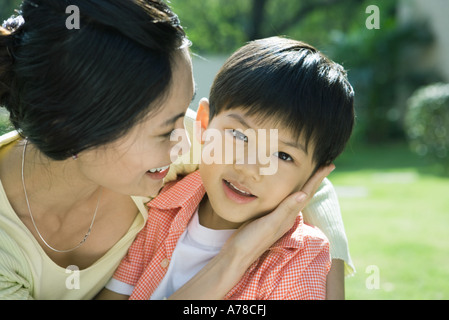 Mutter und Sohn, Frau mit Hand auf der Wange des jungen, jungen Blick in die Kamera Stockfoto
