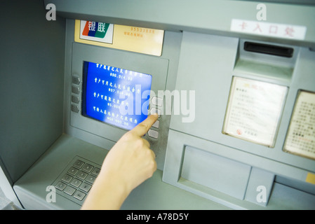 Person mit Geldautomat, verkürzte Ansicht Stockfoto