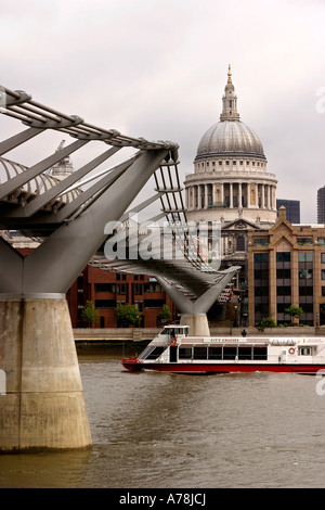 UK London Millennium Bridge über die Themse in der Nähe von St Pauls Cathedral mit Touristenboot auf Fluss Stockfoto