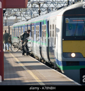 Stratford London Bahnhof Plattform Personenzug wartet man Radfahrer boarding Schlitten mit Fahrrad Newham East London England UK abzuweichen. Stockfoto