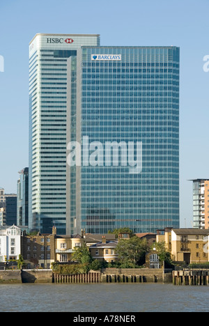 London Docklands Fluss Themse Barclays & HSBC Bank Büro Türme dwarfing ältere waterside Wohnhäuser Stockfoto