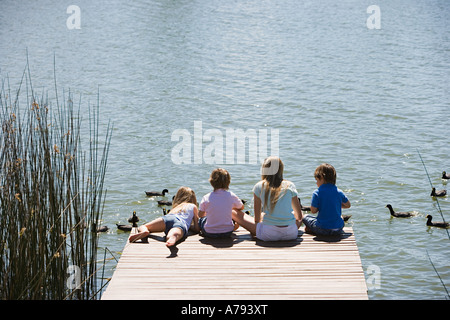 Kinder füttern Enten auf einem See Stockfoto