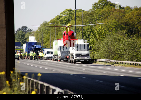 Luft Krankenwagen Hubschrauber Teilnahme an RTA auf Autobahn M6 abheben von Fahrbahn nach dem Aufsaugen von verletzten Stockfoto