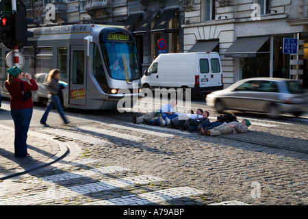 Frau fotografieren sechs Personen liegen in der Straße vor einer Straßenbahn Brüssel Belgien Stockfoto