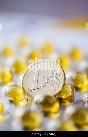 Ein-Euro-Münze unter Vitamin E Kapseln. Konzeptbild, Tageslicht Stillleben erschossen. Stockfoto