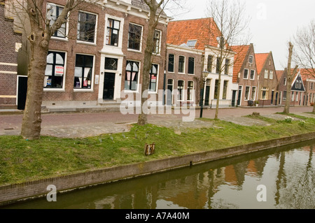 Malerischer Gracht-Wasserkanal und Häuser in Edam Nord-Holland. Traditionelle niederländische Architektur und historische Backsteingebäude entlang einer ruhigen Wasserstraße. Stockfoto