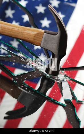 amerikanische Flagge mit Hammer auf ein gebrochenes Stück Glas reflektiert. Stockfoto