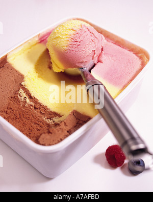 Nahaufnahme von Schokolade Vanille und Himbeere Eis in einer Wanne mit Schaufel Stockfoto