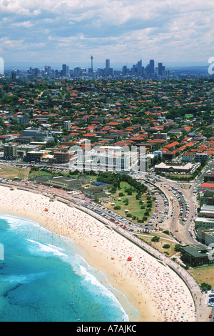 Luftaufnahme der Sonnenanbeter am sandigen Ufer des Bondi Beach in Sydney mit Skyline der Stadt darüber hinaus Stockfoto