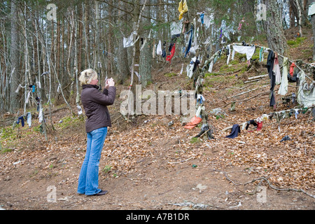 Touristen, die in Clootie gut fotografieren, wurden Stoffstreifen oder Lumpen zurückgelassen, die in einem Heilritual an die Äste des Baumes gebunden wurden. Munlochy, Großbritannien Stockfoto