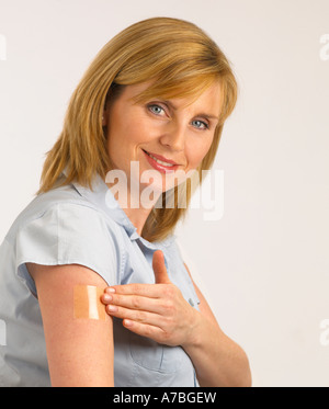 ATTRAKTIVE GESUNDEN JUNGEN BLONDEN FRAU ANWENDUNG TRANSPARENT NIKOTIN PATCH ARM Stockfoto