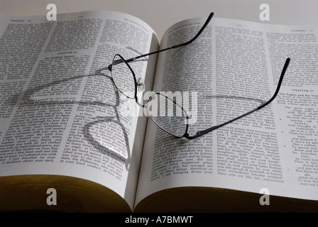 Lesebrille mit Schatten auf großes Buch der Götter Wort die Bibel Stockfoto