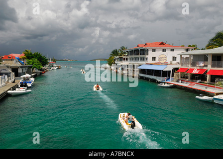 Linie der Bootsfahrer im Wasserkanal an Sandy Ground Bridge St Martin mit Gewitterwolken Stockfoto