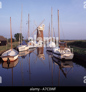 Horsey Staithe Windpumpenentwässerung Windmühle Grad II gelistetes Gebäude auf Broads Wasserstraßen verankerte Boote reflektiert in stillem Wasser Norfolk East Anglia UK Stockfoto