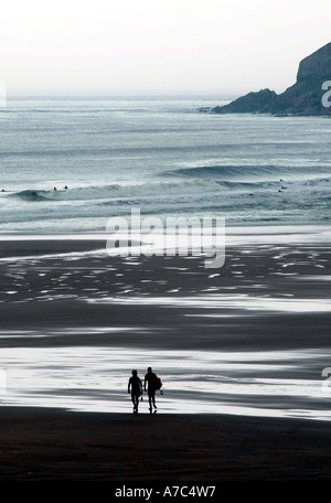 Zwei Surfer Silhouette Strand entlang spazieren Stockfoto