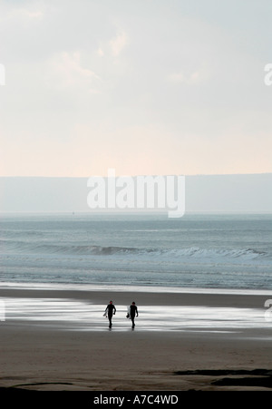 Zwei Surfer Silhouette Strand entlang spazieren Stockfoto