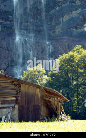 Holzchalet vor Wasserfall in der Nähe von Interlaken, Schweiz Stockfoto