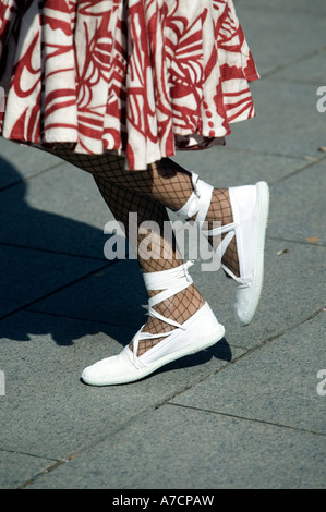 Beine der jungen Frau tanzt La Sardana tragen Netzstrumpfhose und weiße Schuhe Pla De La Seu Barcelona Katalonien Spanien Stockfoto