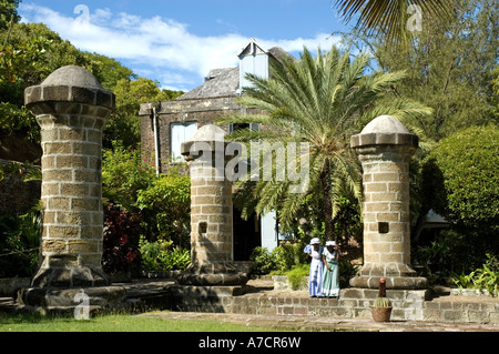 Zwei weibliche Insider im 17. Jahrhundert Kleider stehen den Boot Haus und Segel Loft Säulen, Nelsons Dockyard, Antigua Stockfoto