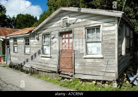 Ein altes Haus der Schindeln mit einem Wellblechdach gebleicht zu einem stumpfen Grau von der heißen tropischen Sonne, St. John, Antigua Stockfoto