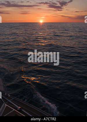 Blick nach unten auf Deck der Segelboot über Steuerbord Schienen bei hellen gelben Sonnenuntergang am Horizont in der Bristol Channel UK Stockfoto