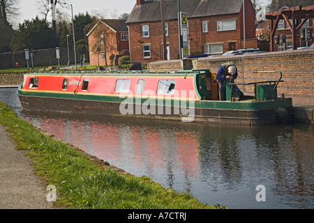 WELSHPOOL POWYS MID WALES UK März einen Mann arbeitet auf eine grüne und rote Narrowboat am Montgomery Kanal Stockfoto