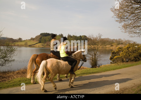 LLANDECWYN GWYNEDD NORTH WALES UK April zwei junge Damen reiten ihre Ponys herum sehr noch Llyn Tecwyn Uchaf Stockfoto