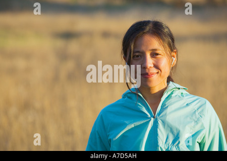 Junge Frau im freien Kopfhörer anhören Stockfoto