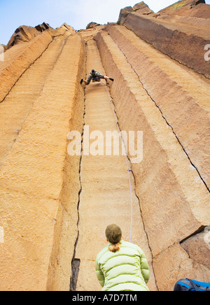 Einem niedrigen Winkel Ansicht der beiden Frauen Klettern auf Basalt Säulen in Zentral-Oregon Stockfoto