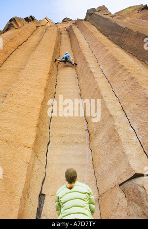 Einem niedrigen Winkel Ansicht der beiden Frauen Klettern auf Basalt Säulen in Zentral-Oregon Stockfoto